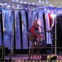 Gallery 2 - Bob on stage with banners behind.