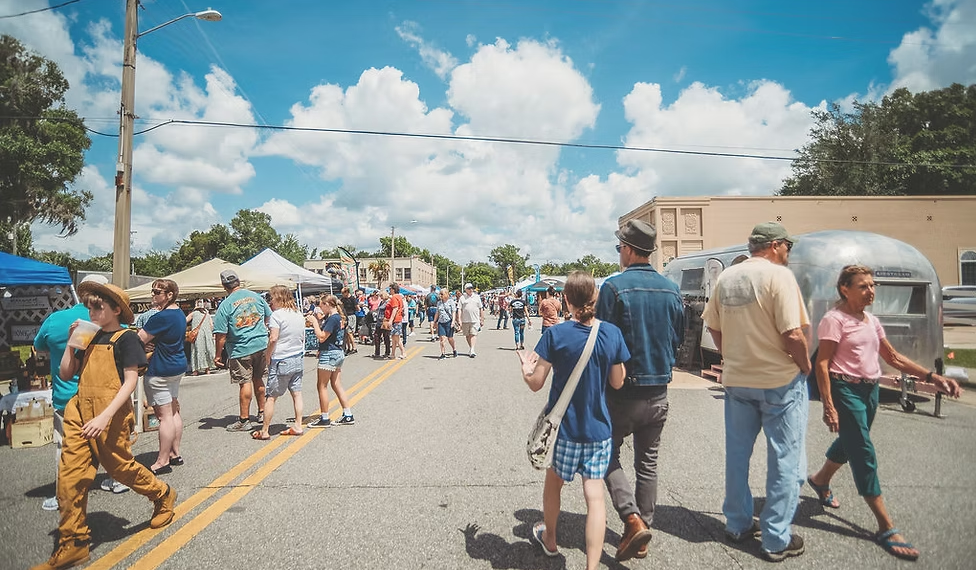 Gallery 1 - People enjoying artisans and vendors off main street.