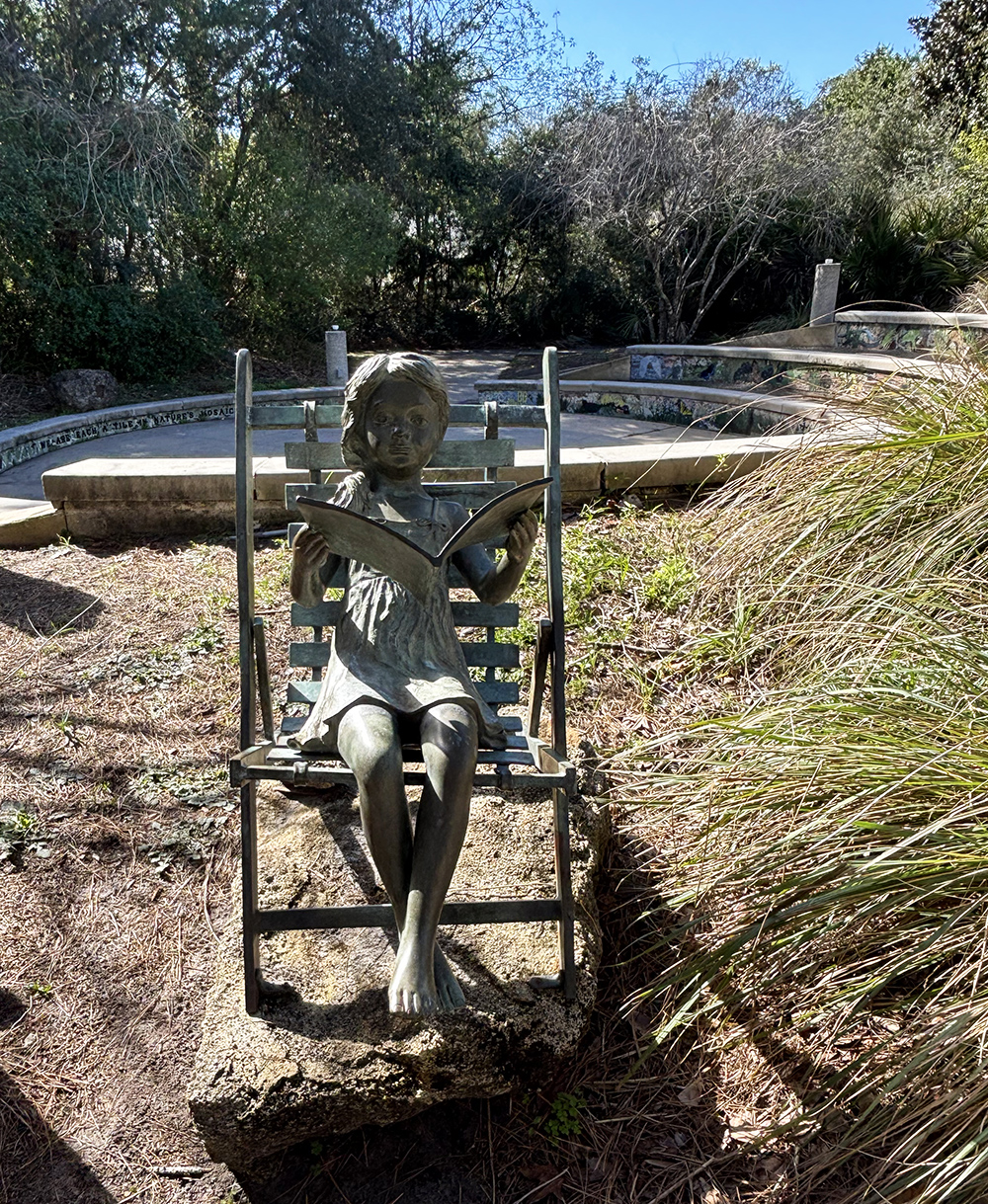 Gallery 2 - Bronze sculpture of a girl reading a story. The sculpture sits at the entrance of the storytelling amphitheatre.