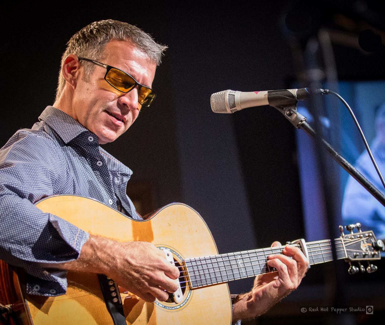 Gallery 1 - Sam Pacetti playing acoustic guitar on stage.